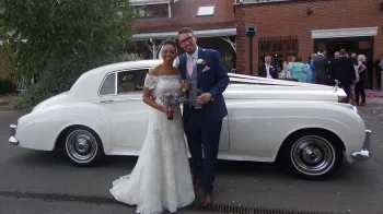 couple standing ion front of the car for photos