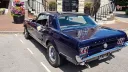 rear view of classic blue Ford Mustang Coupe with white bows on door handles