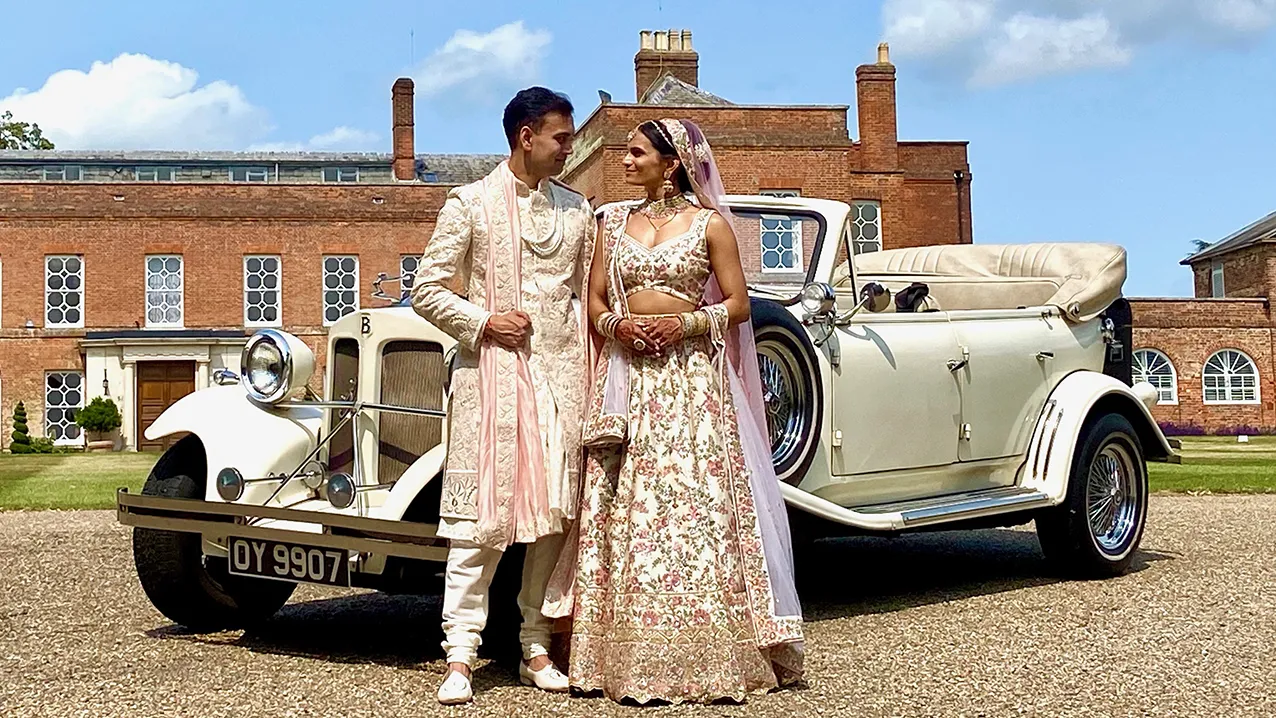 Vintage Beauford Convertible with Asian Bride and Groom standing in front of the car